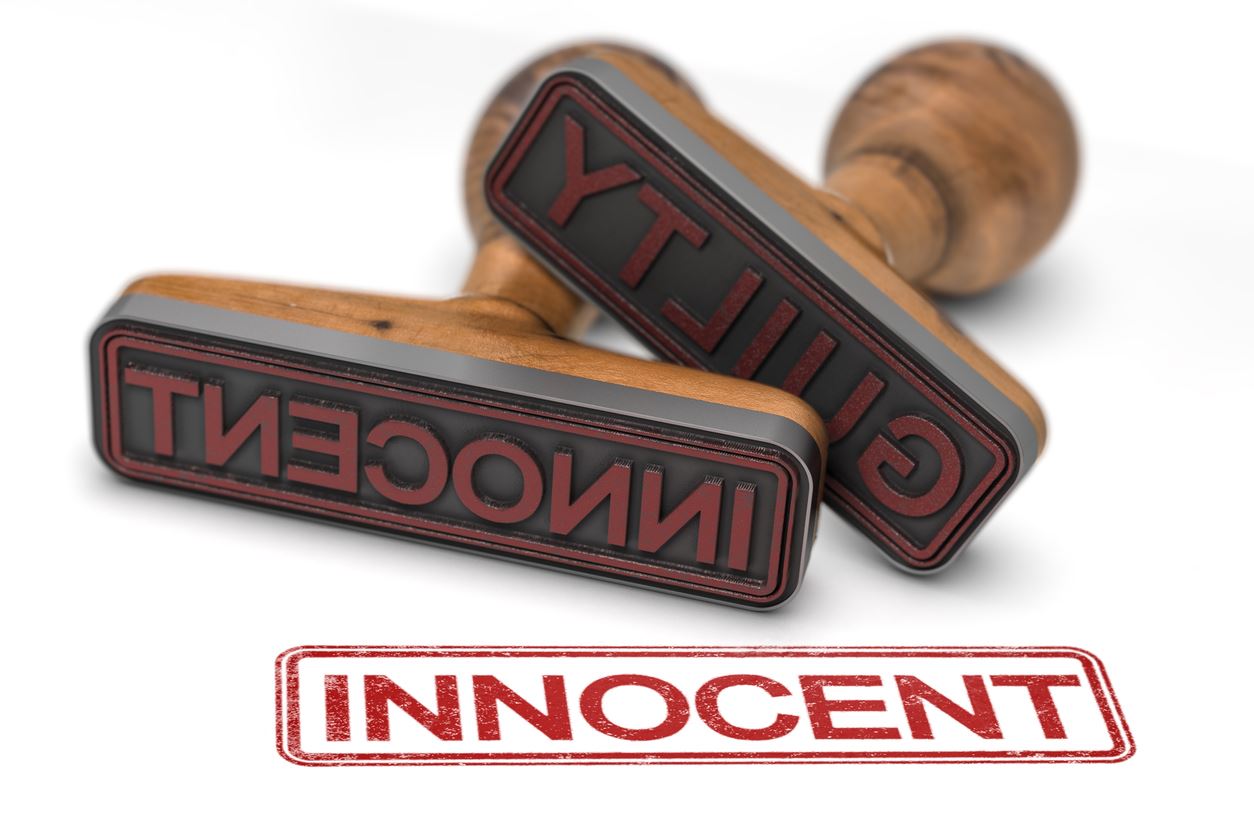 Two rubber stamps over white background with the words guilty and innocent, focus on the second one.